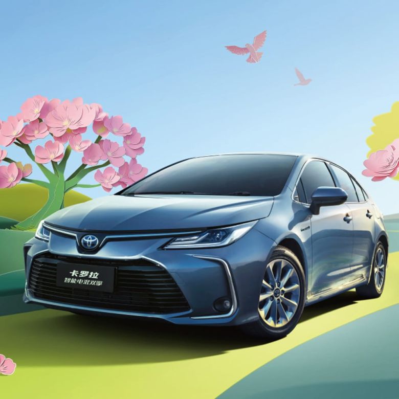 A blue Toyota Corolla Intelligent Electric Hybrid car in a scenic, spring - like setting with pink flowers and birds
