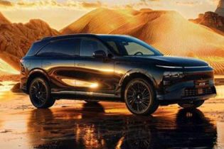 Xpeng G9 parked on reflective wet ground, set against a glowing golden desert landscape at sunset.