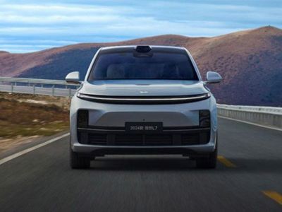 The 2024 Leapmotor C11 drives on a scenic road, with rolling hills in the background, showcasing its sleek electric SUV design and advanced autonomous driving sensor setup.