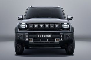 The 2025 Jetour Traveler SUV, in a sleek gray finish, features a bold front design with prominent "JETOUR" branding and rugged off-road elements, showcased against a minimalist gray backdrop.
