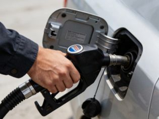 A gas station attendant is filling up a car