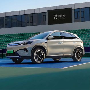 A light - colored BYD Yuan Plus electric SUV parked on a tennis court.