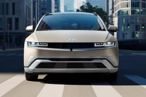 Hyundai IONIQ 5: Futuristic beige EV cruising city streets, blending sleek design with eco-friendly urban mobility.