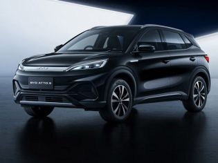 Sleek black BYD ATTO 3 electric SUV showcased in a modern, minimalist studio setting with a reflective dark floor.