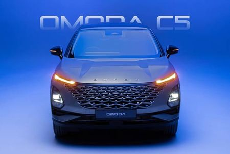 Front view of the black Omoda C5 car with its headlights on, set against a blue background with "OMODA C5" text.
