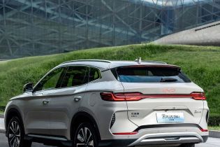 Silver BYD Song PLUS DM-i SUV (rear side view): Parked by a modern glass building and grassy hill. Features red "BYD" badge, taillights, and "Song PLUS DM-i 2025" label.