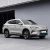 A silver BYD Song PLUS DM-i SUV parked in front of a modern building, highlighting its sleek design and stylish alloy wheels in an urban setting.