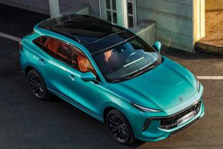 A turquoise Forthing T5 EVO SUV with a black roof, captured in an overhead view, parked on a paved area near a modern building, highlighting its sleek and dynamic design.