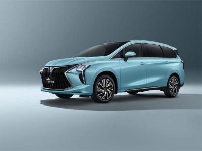 A light blue MPV with a bold front grille and panoramic sunroof is showcased against a plain background, highlighting its modern and spacious design.