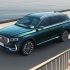 A dark green Geely SUV by the water.