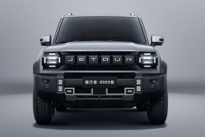 The 2025 Jetour Traveler SUV, in a sleek gray finish, features a bold front design with prominent "JETOUR" branding and rugged off-road elements, showcased against a minimalist gray backdrop.