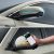 Two images showing a car's side mirror with LED lights and a hand holding a smartphone interacting with the car.
