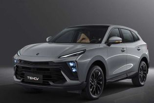 A silver T5 HEV SUV with black accents, showcased against a dark background, highlighting its modern design, illuminated headlights, and sleek black alloy wheels.