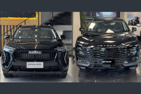 Two black SUVs (Haval and Jetour) displayed indoors at a car dealership showroom.