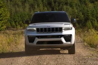 A gray 2026 Jeep Grand Cherokee L Summit traveling down a coastal highway