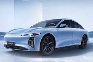 The Xinghai S7, a light blue electric sedan with a sleek design, black wheels, and a modern aesthetic, showcased against a minimalist, light blue background.