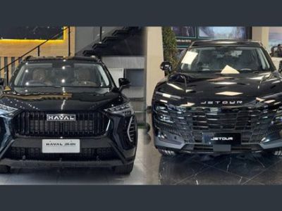 Two black SUVs (Haval and Jetour) displayed indoors at a car dealership showroom.