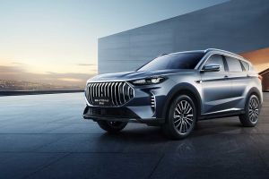 A silver Jetour X70 PLUS SUV parked on a modern, sleek pavement with a minimalist architectural background and a scenic sunset view.