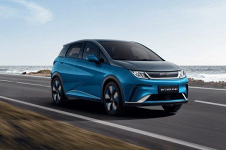 BYD Dolphin EV: Sleek blue hatchback cruising coastal roads, blending eco-power with dynamic city driving.