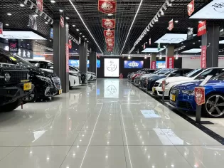 Diverses voitures exposées dans une salle d'exposition bien éclairée, décorée de banderoles pour une célébration du 5e anniversaire.