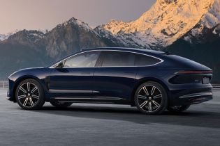 Side view of a dark blue NIO ET9 electric car with snow-capped mountains in the background.