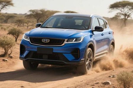 A blue Geely SUV driving on a dusty dirt road in a desert - like landscape with sparse trees.