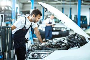Workers are performing maintenance on the car
