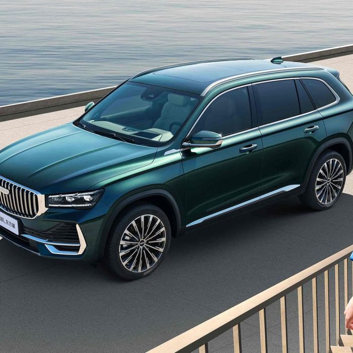 A dark green Geely SUV by the water.