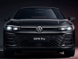 Front view of the black Volkswagen Passat Pro sedan, featuring illuminated headlights and a honeycomb grille, set against a dark background with red accents, highlighting its modern and bold design.