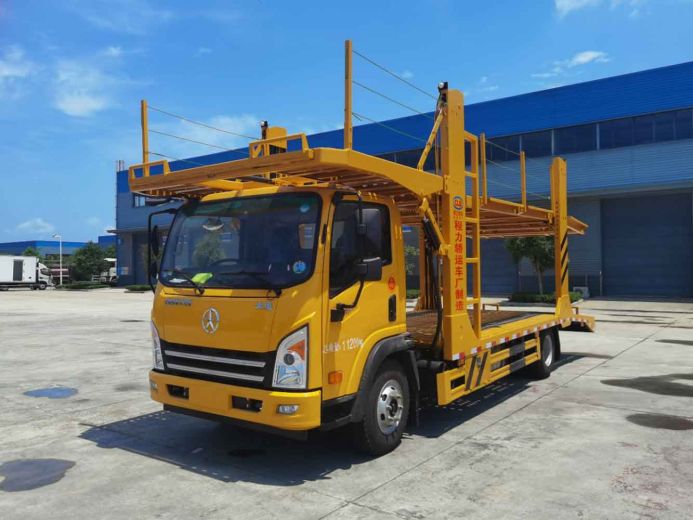 A yellow Dayun car carrier truck parked in an industrial area.