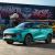 A turquoise Fengon T5 EVO SUV parked in front of a vibrant graffiti-covered container, showcasing a trendy urban scene with colorful street art.