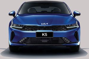 Front view of a blue Kia K5 sedan, highlighting its sleek headlight design, black grille, and "K5" badging, embodying a sporty and modern aesthetic.