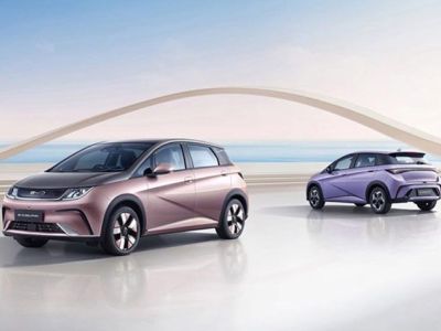 BYD Dolphin (rose gold, purple) in modern space; coastal backdrop with sailboats and arch structure.