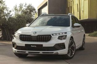 White Skoda Kamiq SUV (front view) parked near a modern building with yellow facade and olive trees. Displays the Skoda logo and "Kamiq" badge on the grille.