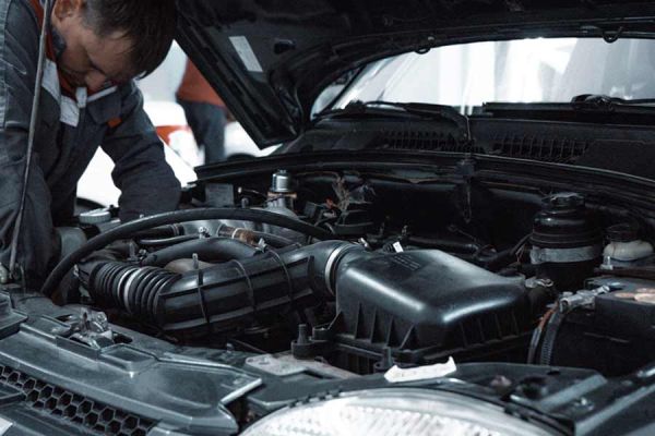 Mechanic inspects car engine compartment