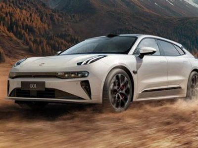 A white Zeekr 001 driving on a dusty terrain, with a backdrop of autumn forests and mountains, showcasing its dynamic off-road performance and sleek design.
