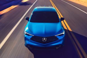 2026 Acura ADX A-Spec shown in Double Apex Blue Pearl II, driving on the road