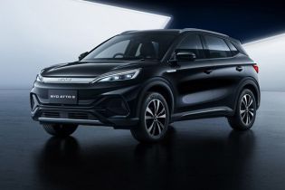 Sleek black BYD ATTO 3 electric SUV showcased in a modern, minimalist studio setting with a reflective dark floor.