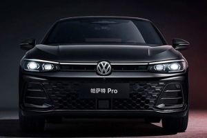 Front view of the black Volkswagen Passat Pro sedan, featuring illuminated headlights and a honeycomb grille, set against a dark background with red accents, highlighting its modern and bold design.