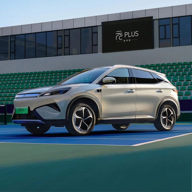 A light - colored BYD Yuan Plus electric SUV parked on a tennis court.