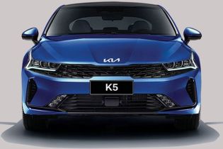 Front view of a blue Kia K5 sedan, highlighting its sleek headlight design, black grille, and "K5" badging, embodying a sporty and modern aesthetic.