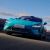 Turquoise Xiaomi SU7 on a road under a blue sky.