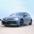 A gray Volkswagen Golf parked on a sandy area under a clear sky.