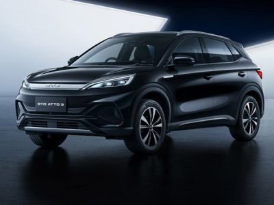 Sleek black BYD ATTO 3 electric SUV showcased in a modern, minimalist studio setting with a reflective dark floor.