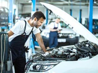 Workers are performing maintenance on the car