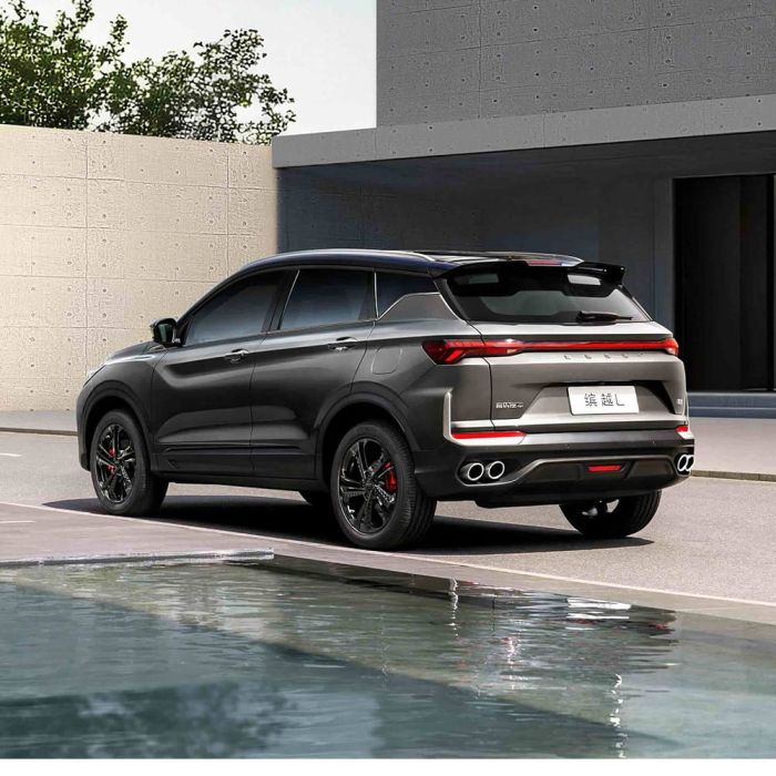 Rear view of Geely BinYue L SUV by a building and water.