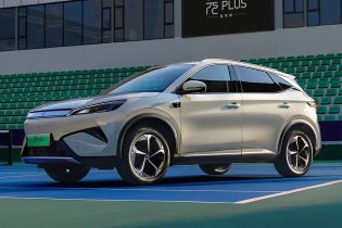 A light - colored BYD Yuan Plus electric SUV parked on a tennis court.