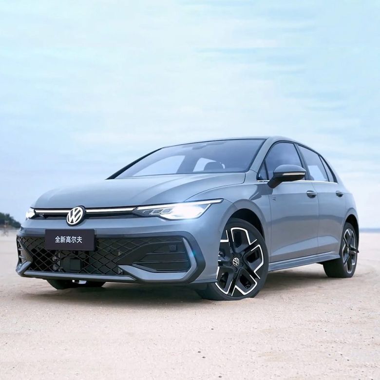 A gray Volkswagen Golf parked on a sandy area under a clear sky.