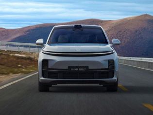 The 2024 Leapmotor C11 drives on a scenic road, with rolling hills in the background, showcasing its sleek electric SUV design and advanced autonomous driving sensor setup.