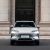 Front view of BYD Song Plus DM-i 2025 model, a silver SUV with distinctive Ocean X Face grille and sleek headlights, parked in front of a grand stone building.